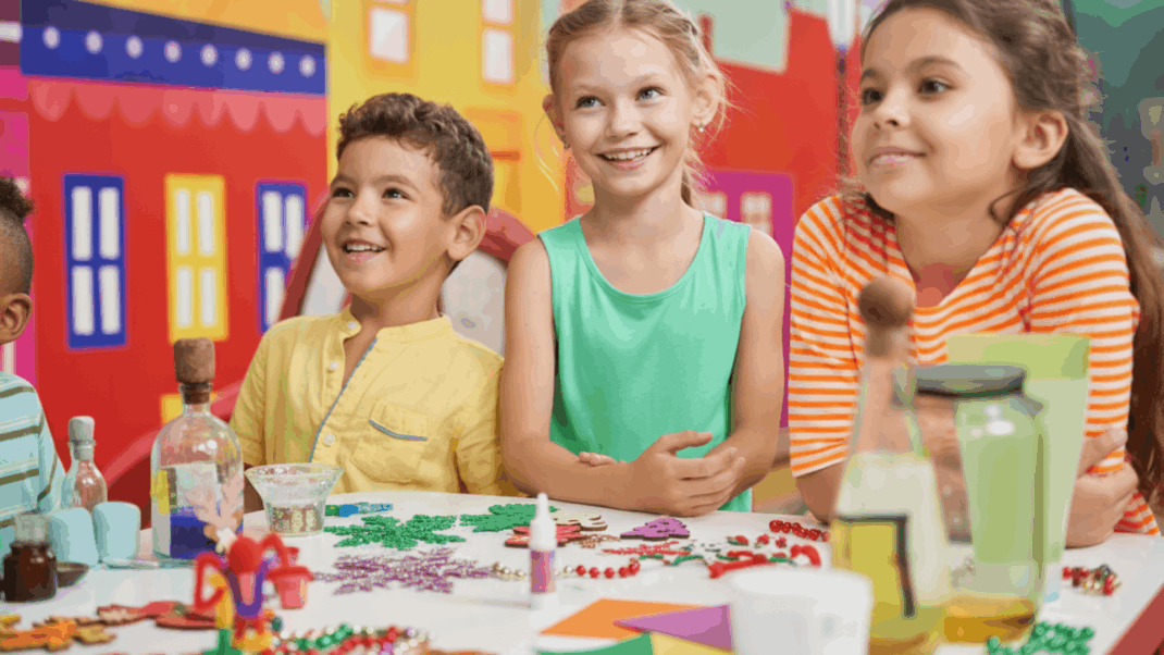 Children smiling sitting around a table.